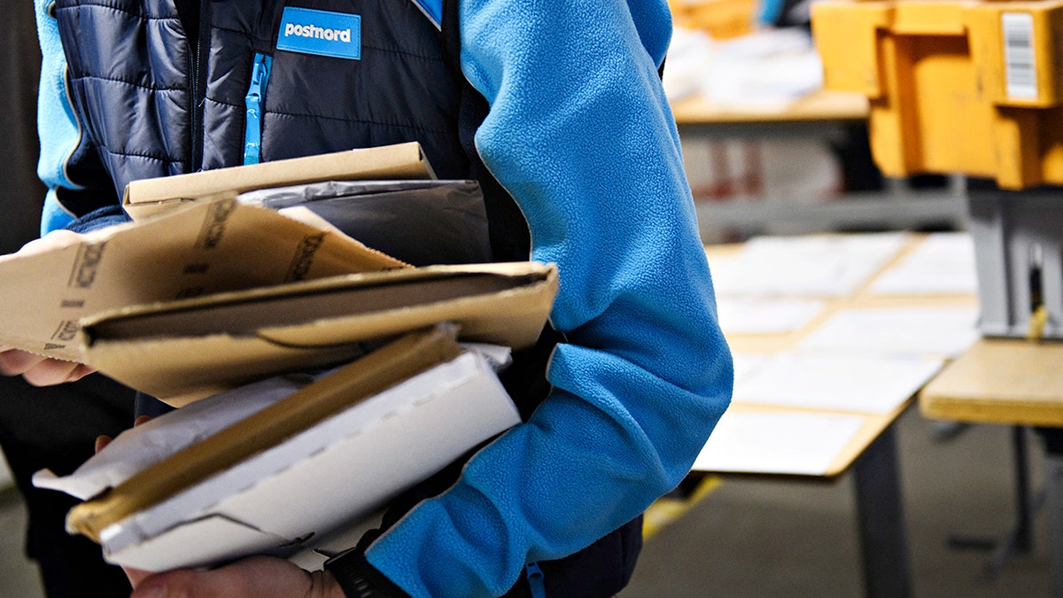 A PostNord employee carries packages.