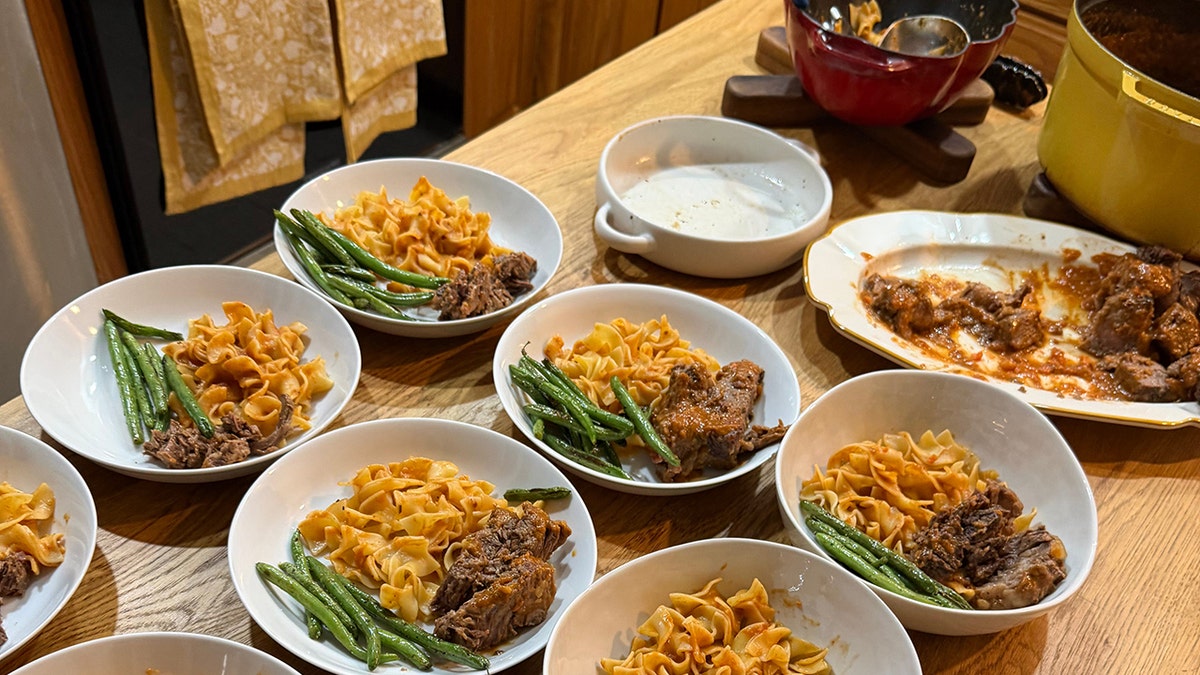 Plates of pot roast, noodles and string beans on counter with pots in background from Mary Neilis' 7kidskitchen Substack.