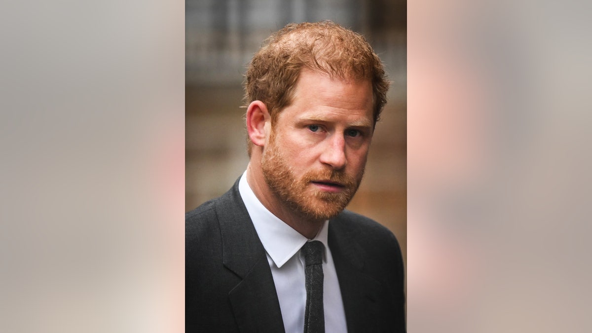 A close-up of Prince Harry in a dark suit.