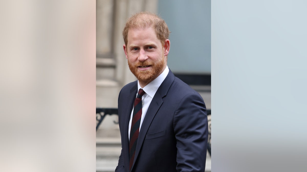 A close-up of Prince Harry wearing a dark blue suit walking to court.
