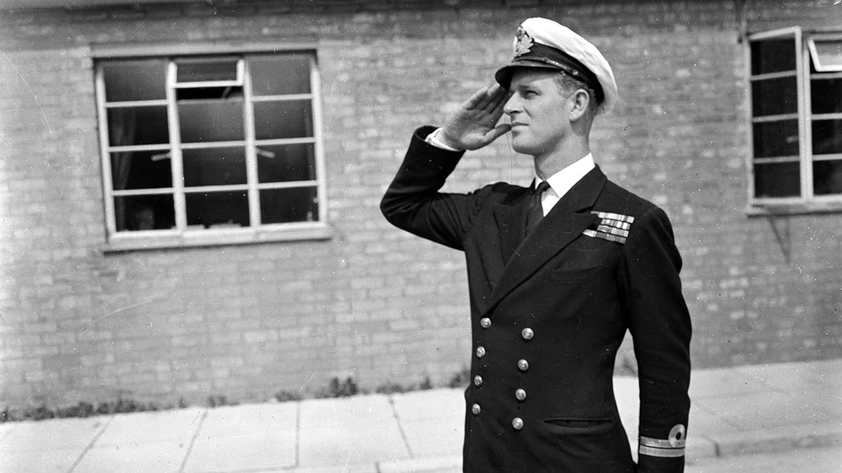 Prince Philip saluting in uniform.