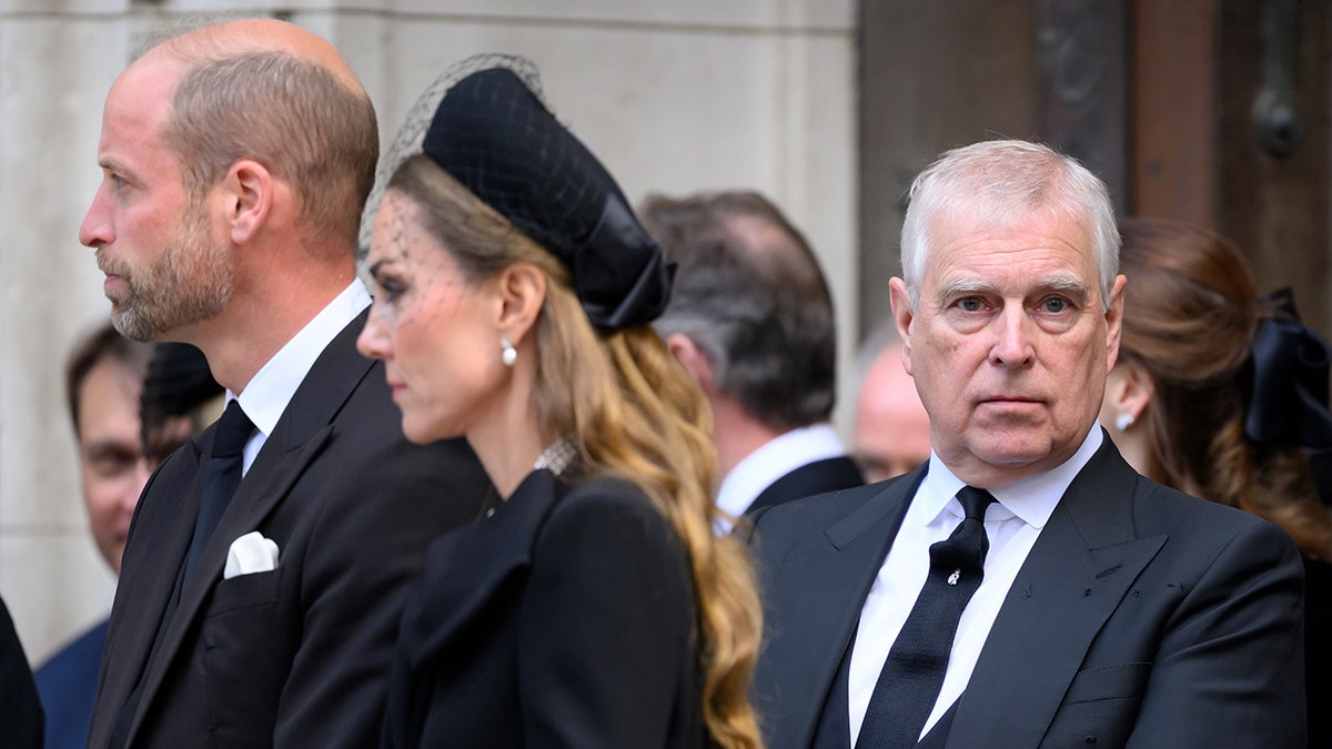 Andrew looking straight at the camera as Prince William and Kate Middleton have their backs turned.