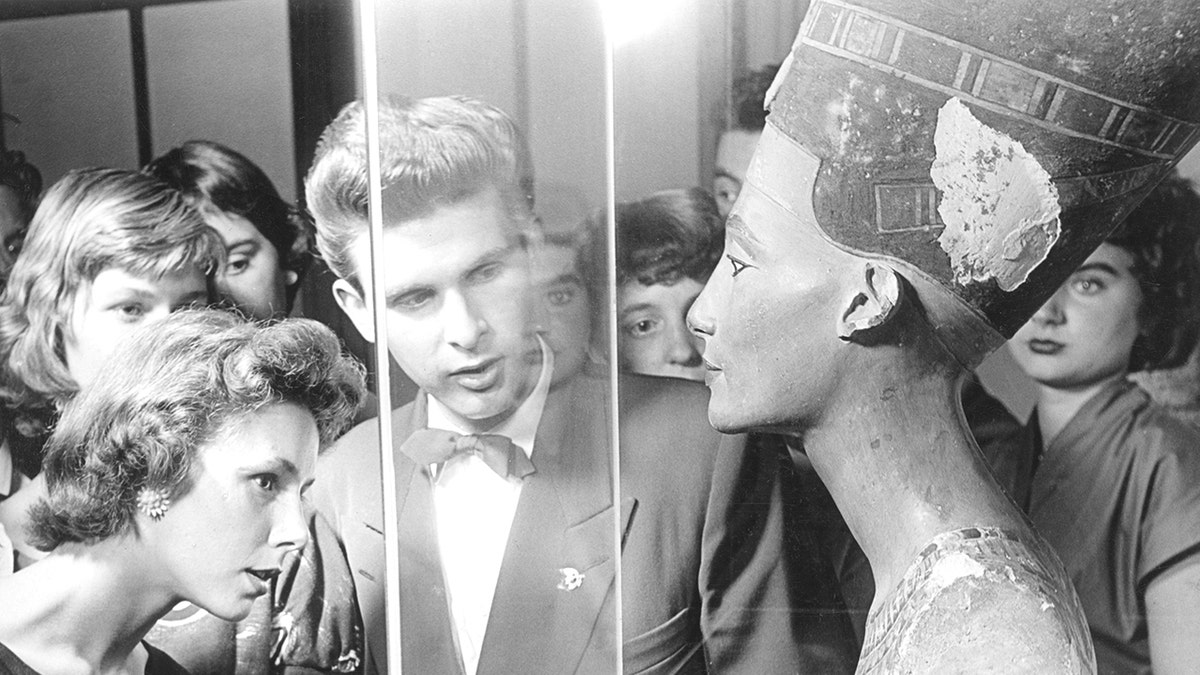 People looking at Nefertiti bust in 1950s