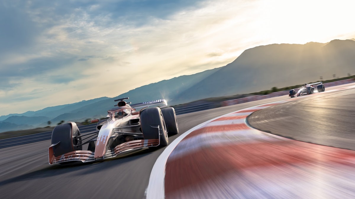 two generic racing cars moving at high speed around a bend 