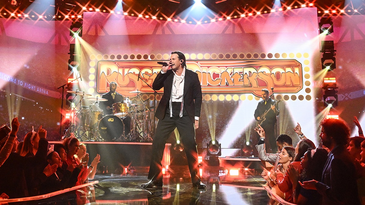 Country music singer Russell Dickerson performs onstage in front of a live audience.