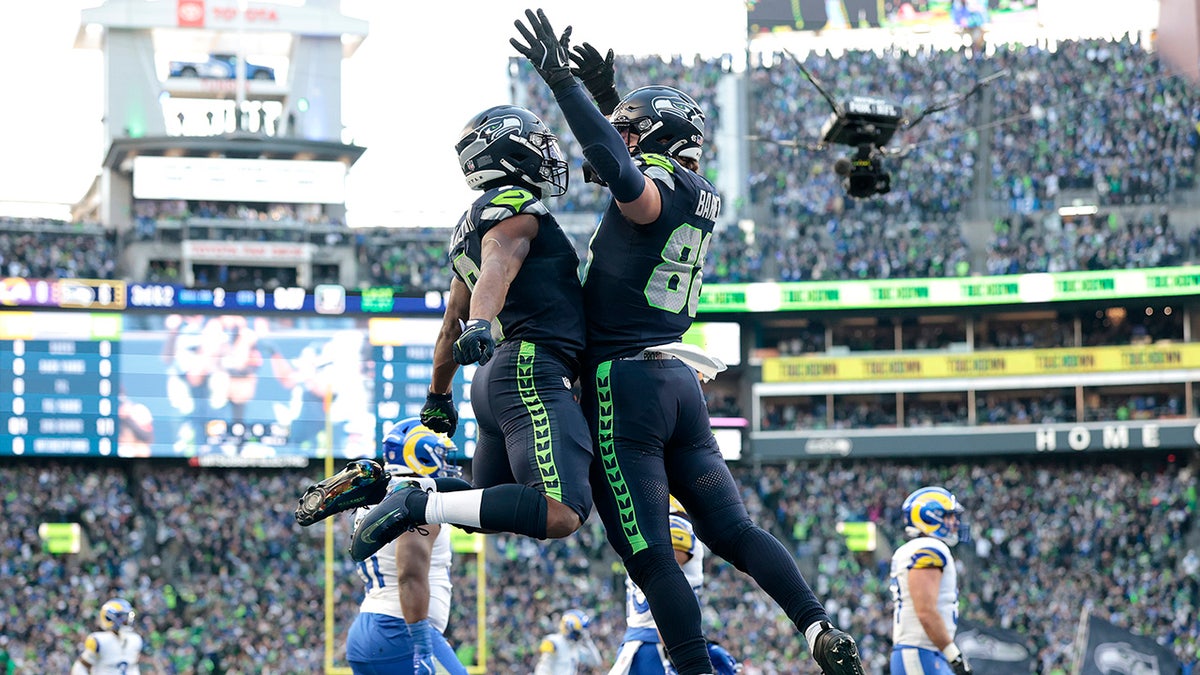 Kenneth Walker III y AJ Barner celebran un touchdown.
