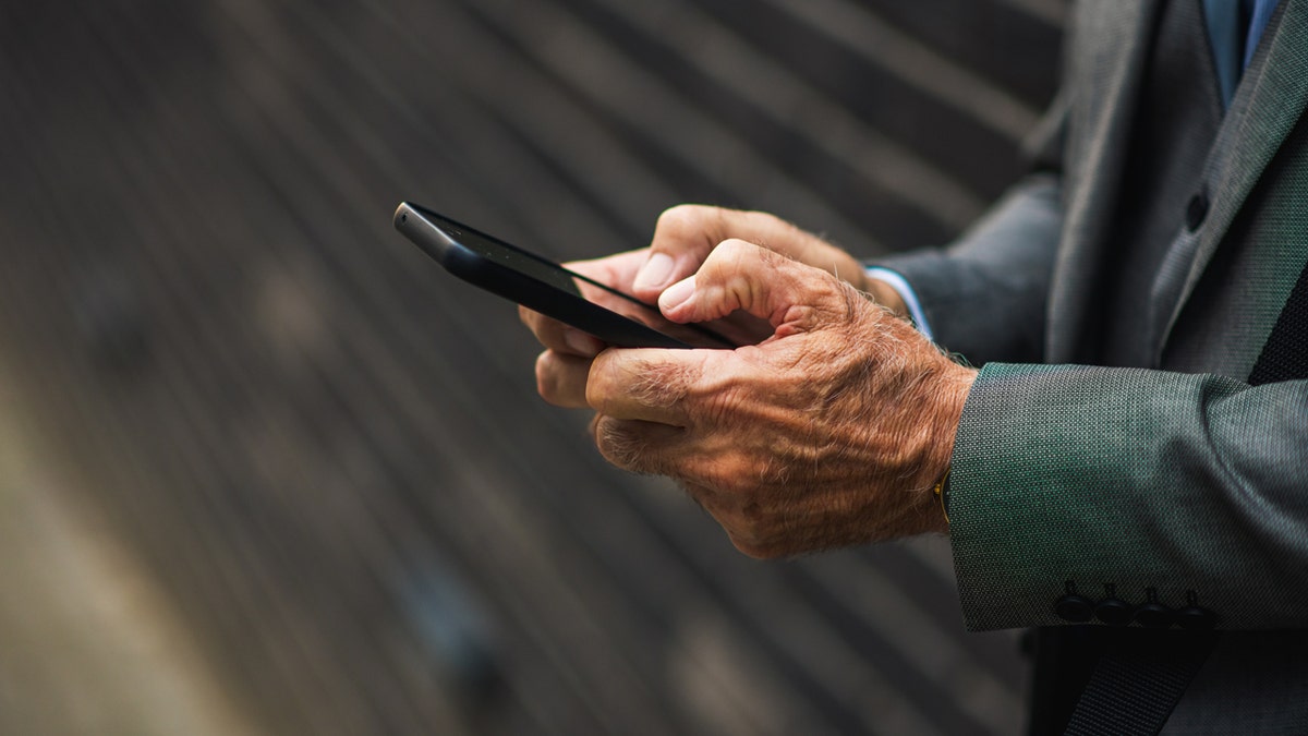 Senior hands holding smartphone