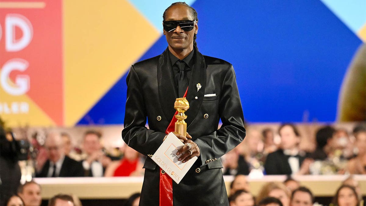 Snoop Dogg holds trophy onstage at Golden Globes