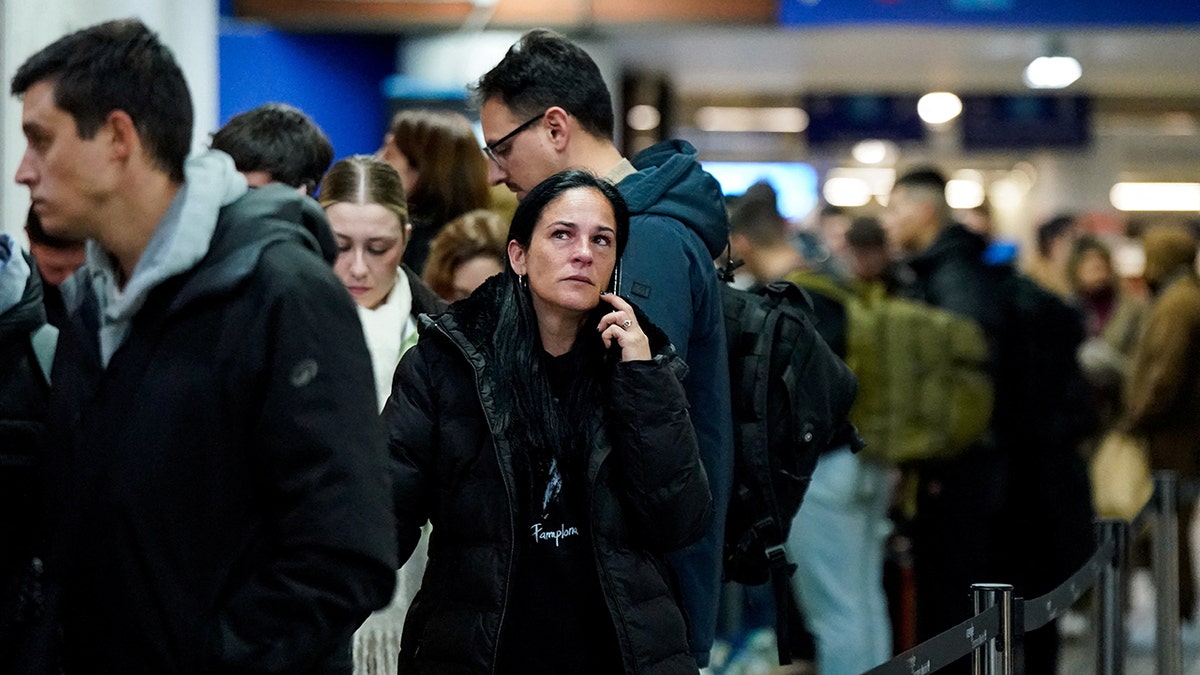 A woman speaks on a mobile phone amid train derailment