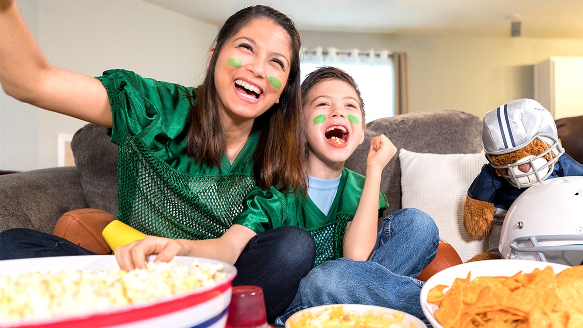 Mom watching Super Bowl game with son