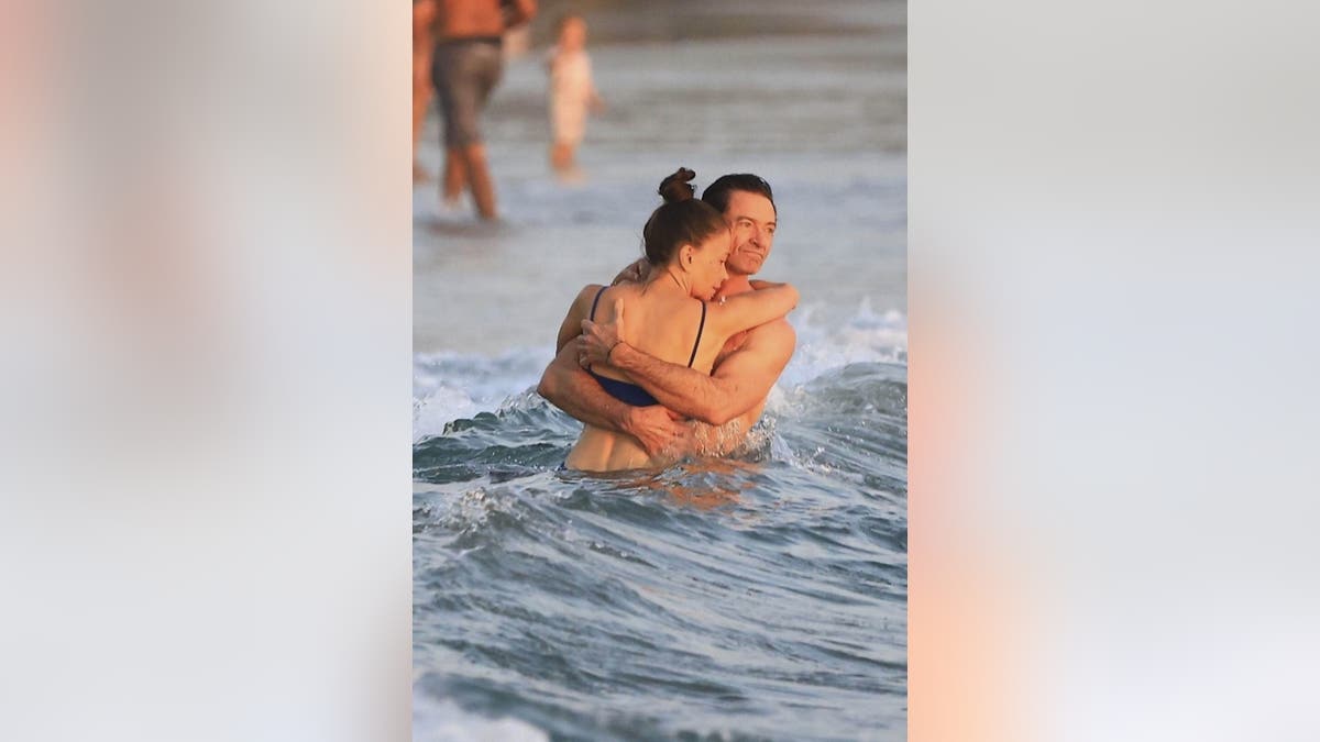 Hugh Jackman and Sutton Foster hug in the water