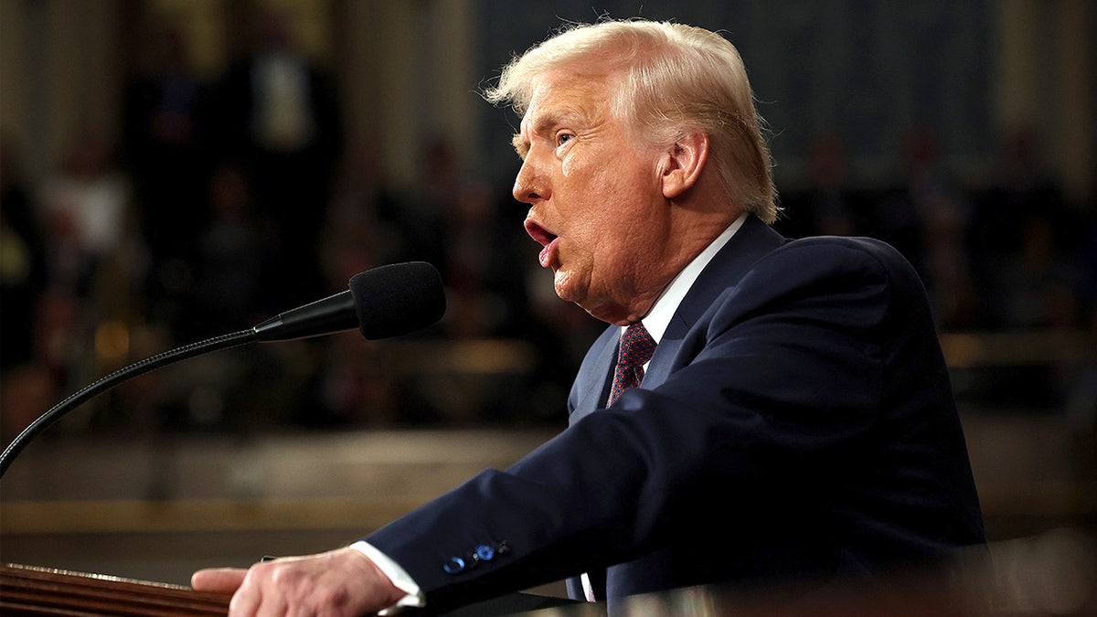 President Donald Trump speaks at a podium while addressing lawmakers inside the U.S. Capitol chamber.