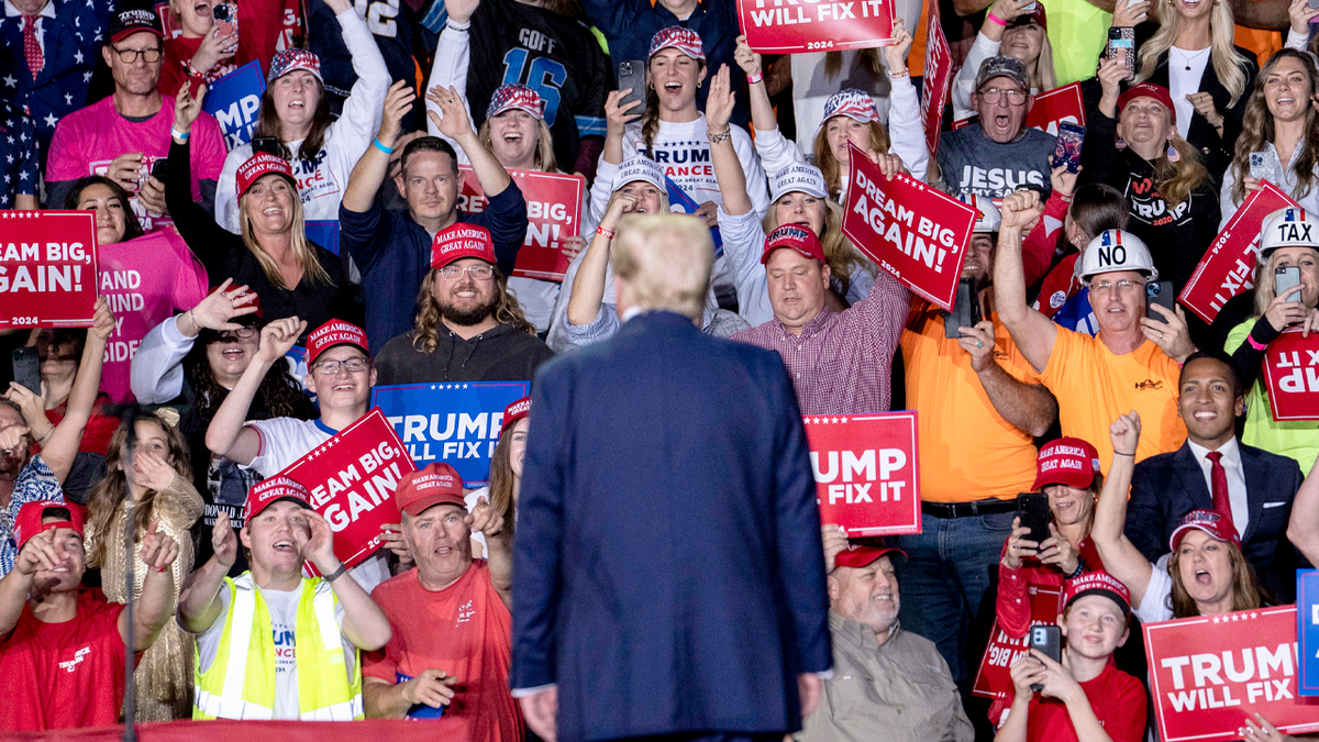 Trump stands and looks at his audience