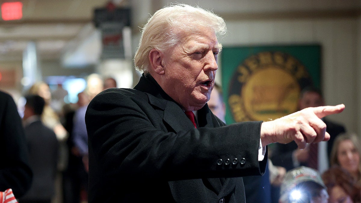 Donald Trump speaks while surrounded by reporters during a visit to a restaurant.