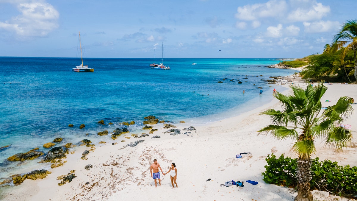 aerial view of aruba with couple walking on beach