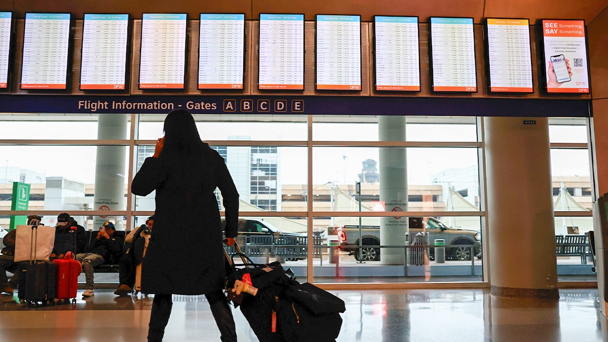 Woman with luggage walks through airport