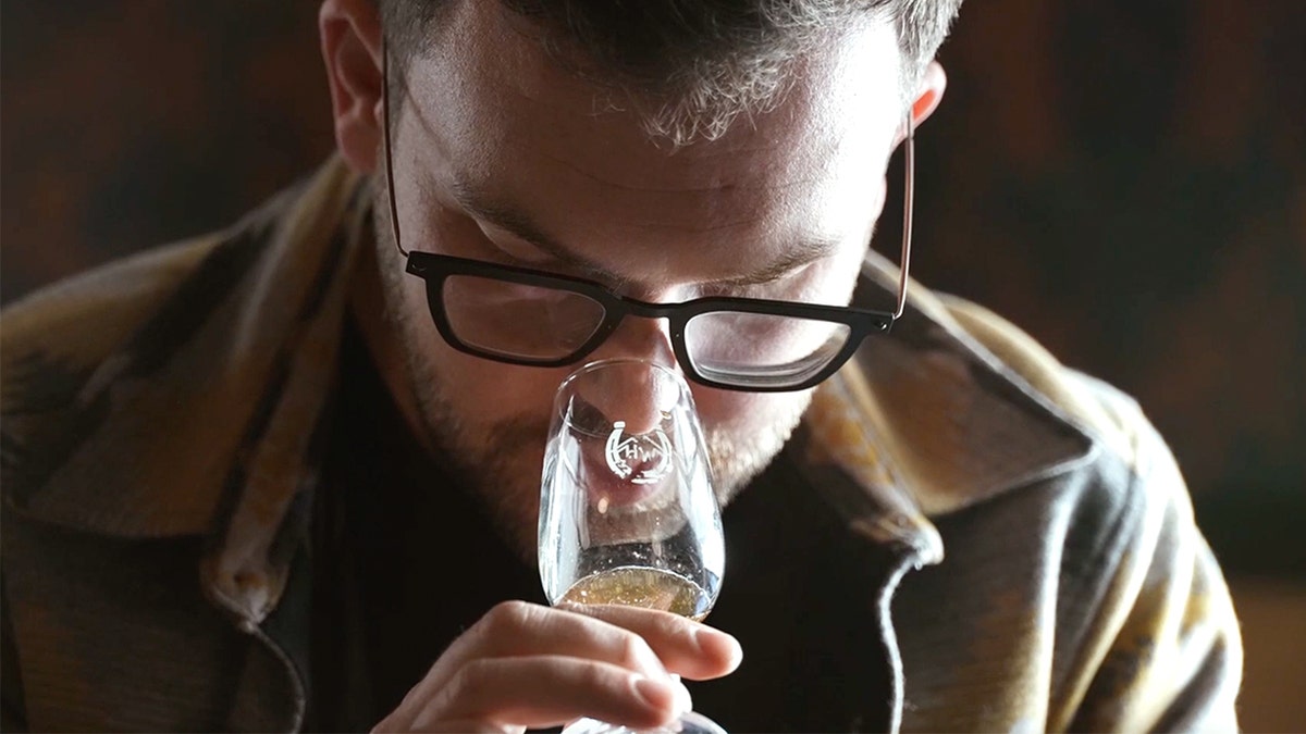 L'uomo annusa il bicchiere di alcol