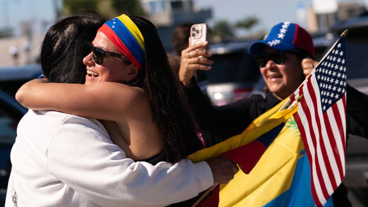 Venezuelans holding U.S. and Venezuelan flags celebrate outside Mar-a-Lago in Palm Beach, Florida.