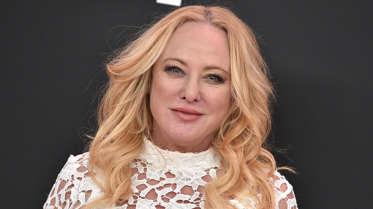 A close-up of Virginia Madsen wearing a white lace dress.