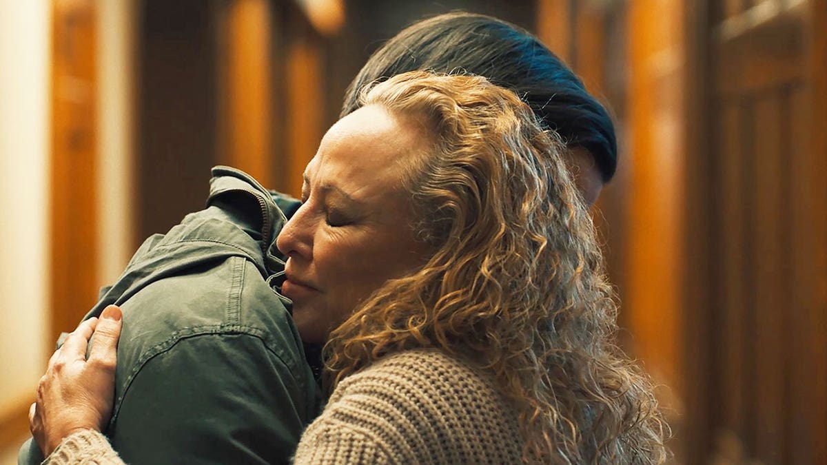 Virginia Madsen hugging a veteran in a scene from the film "Sheepdog."