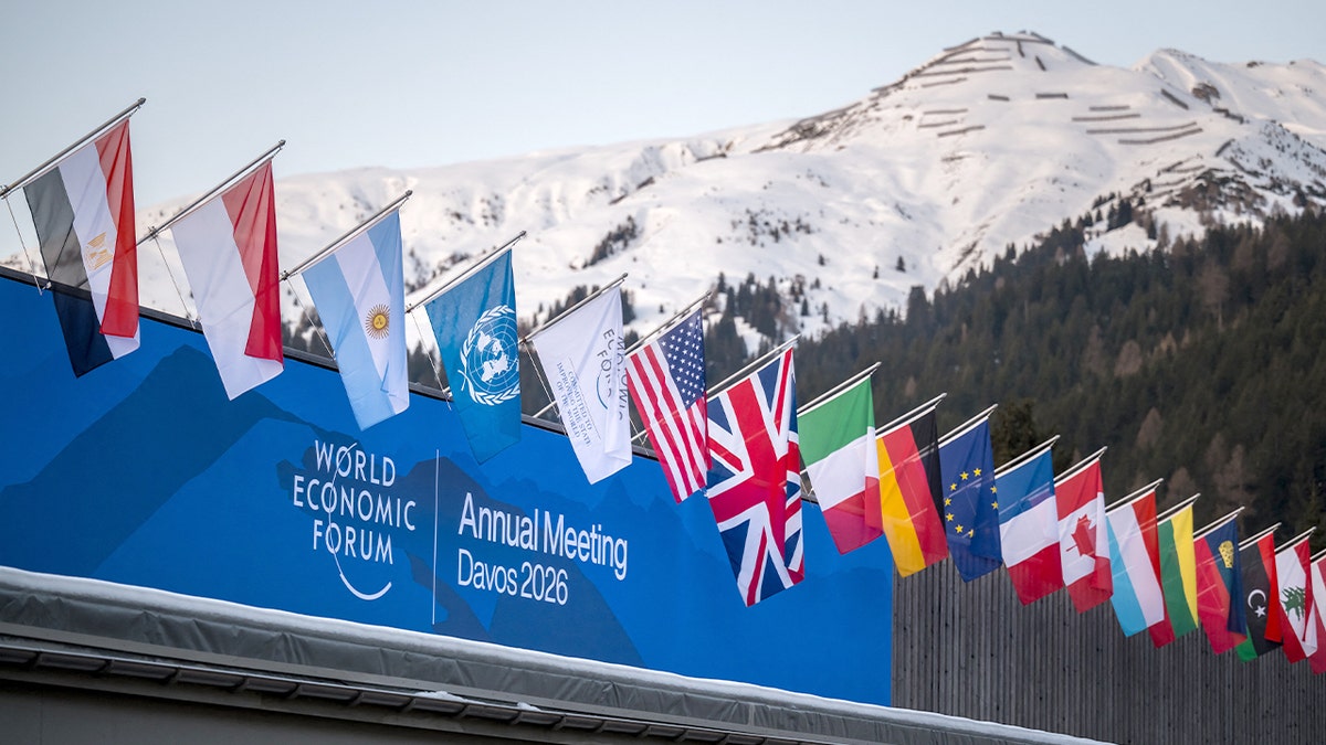 The World Economic Forum logo is displayed atop a conference center in a snowy mountain town.