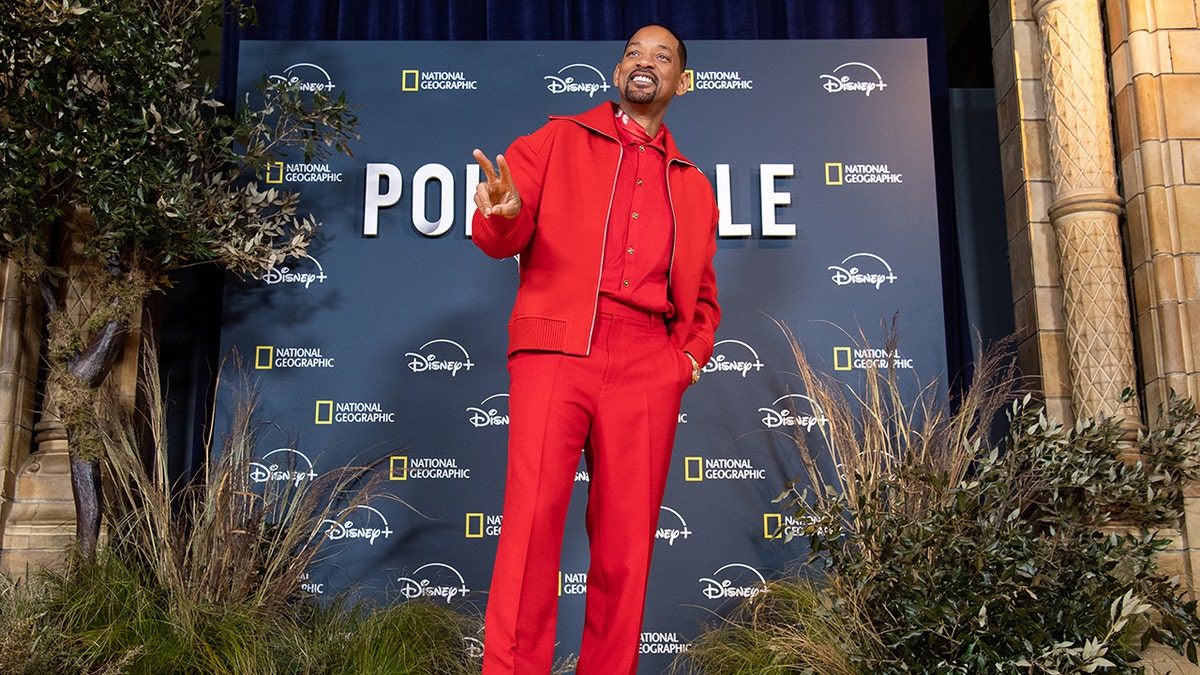 Will Smith smiling in a red outfit