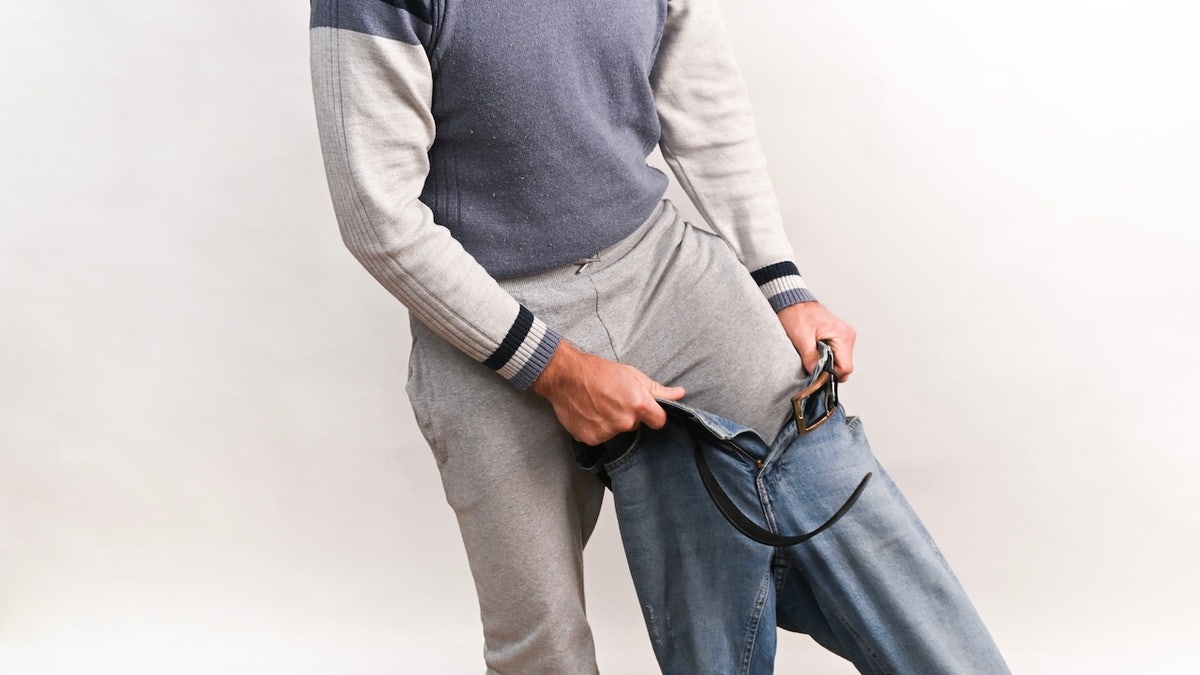 man puts on layers for the cold