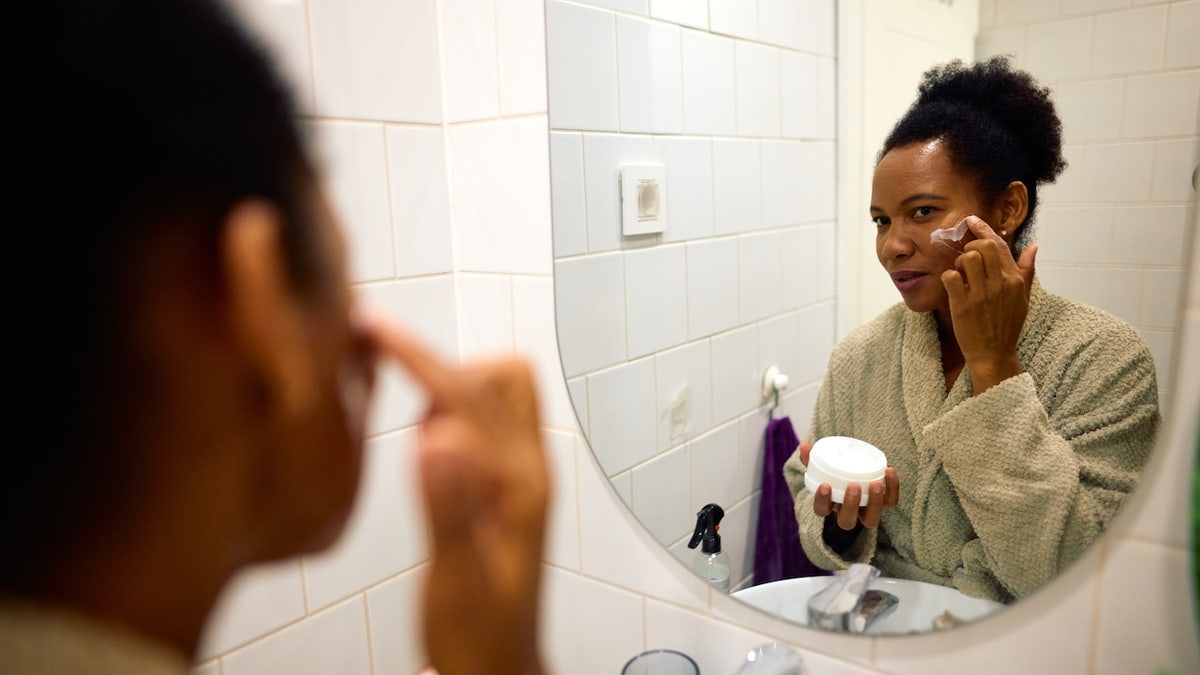 Vrouw gezichtscrème toe te passen