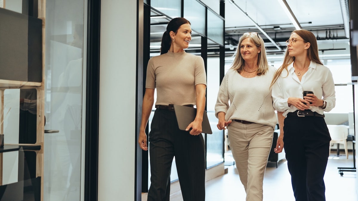 Three businesswomen walking together in an office