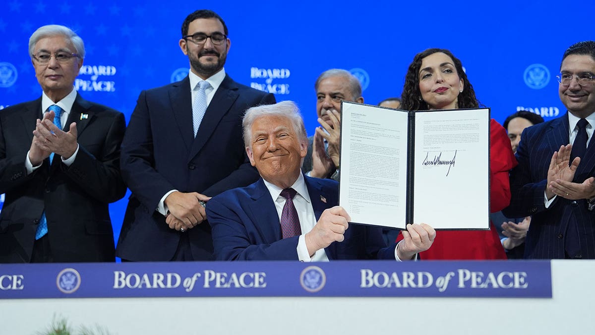 Donald Trump está en el centro de un grupo que sostiene una carta firmada.