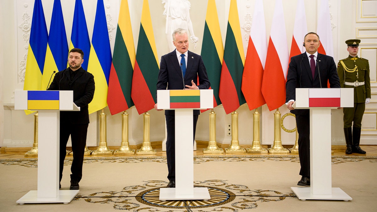 Tres líderes de Europa del Este se suben a un estrado durante una comparecencia conjunta ante los medios de comunicación, frente a los periodistas tras unas conversaciones a puerta cerrada.