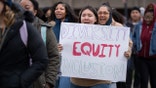 Woman holds DEI sign during protest