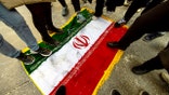 Protesters stomp on a flag during a rally in a central Madrid square.