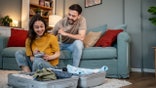 couple packing suitcases for trip