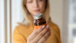 Woman holding a supplement bottle with both hands