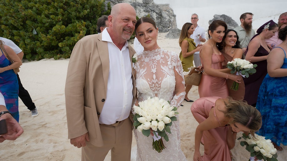 Rick Harrison wears tan suit with wife Angie in white bridal gown.