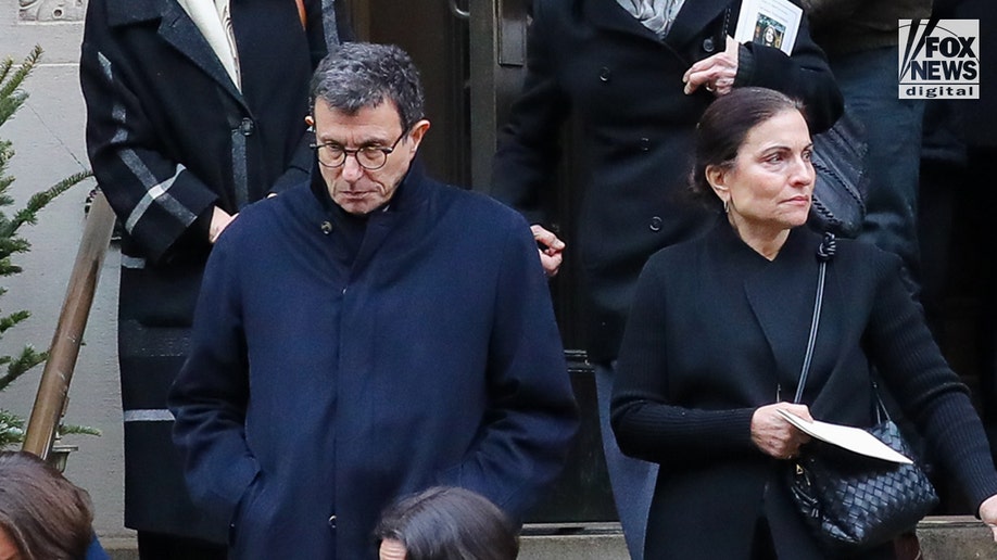 Guests looking sad outside the funeral.