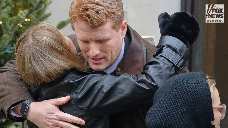 Guests embrace at the funeral.