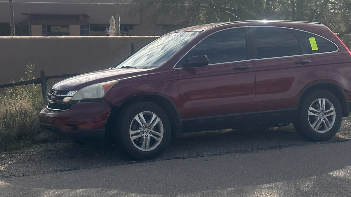 A red Honda with bumper damage.