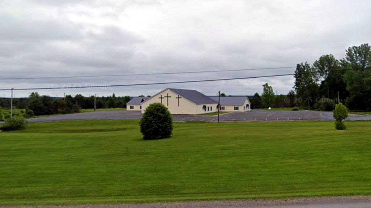 Abundant Life Fellowship church building with three crosses on the facade sitting behind a large green lawn.