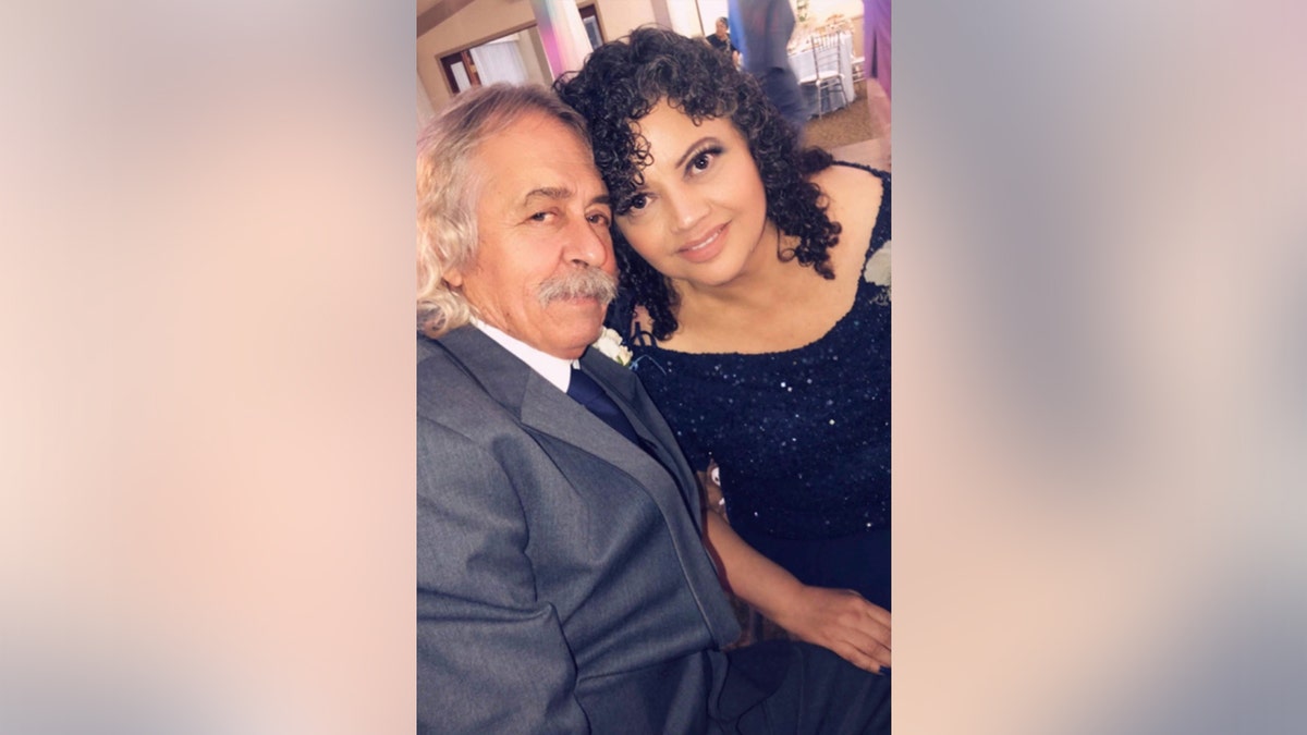 A photo of a couple sitting and smiling at the camera