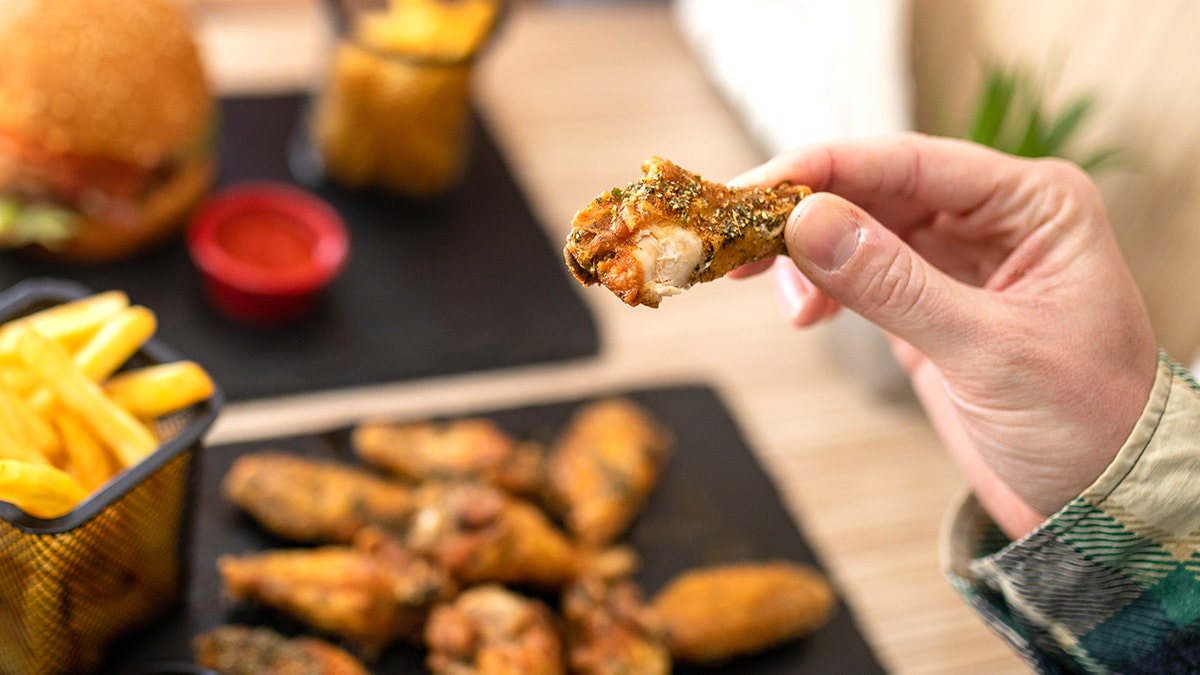 Man holding chicken wing