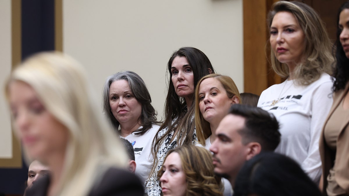 Il procuratore generale Pam Bondi testimonia in un'udienza mentre un gruppo di persone sta in piedi a destra.