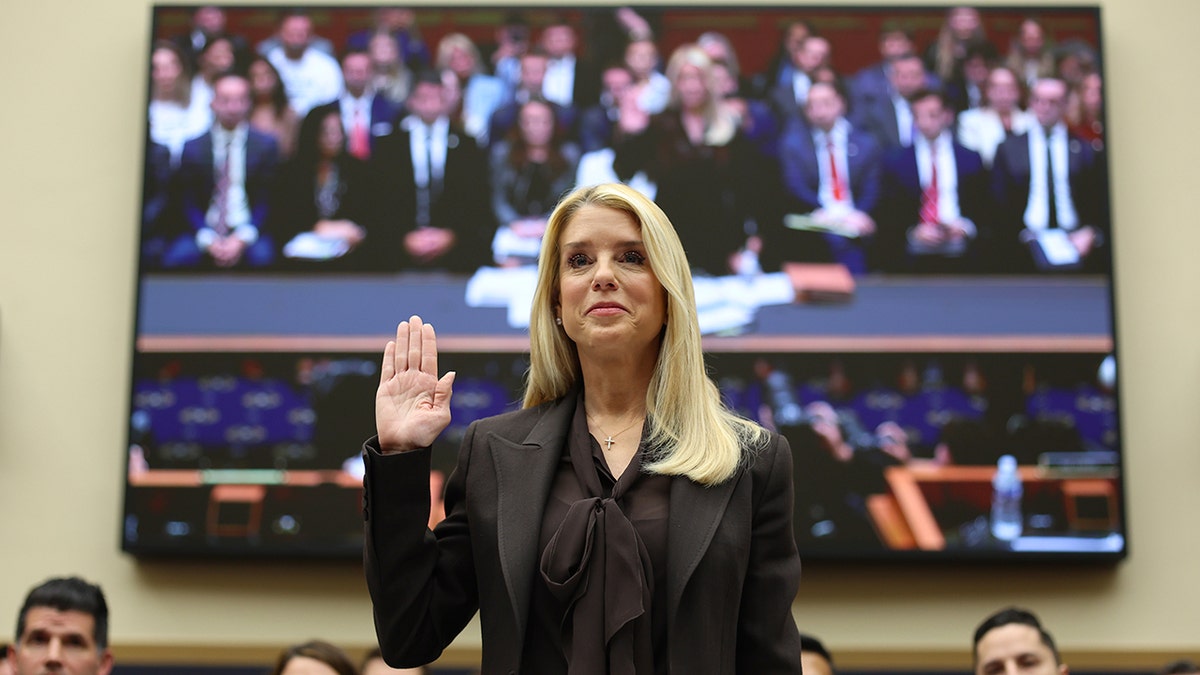 Il procuratore generale Pam Bondi alza la mano destra mentre presta giuramento in un'udienza a Capitol Hill.