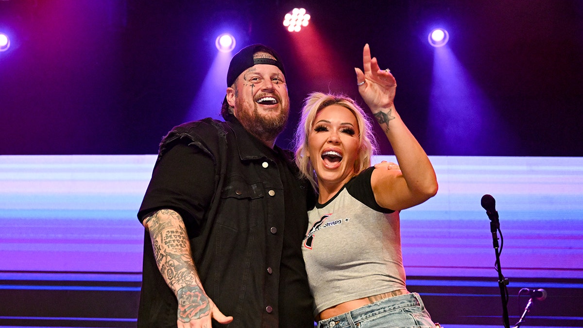 Jelly Roll and Bunnie cheering from the stage during the Academy of Country Music Awards.