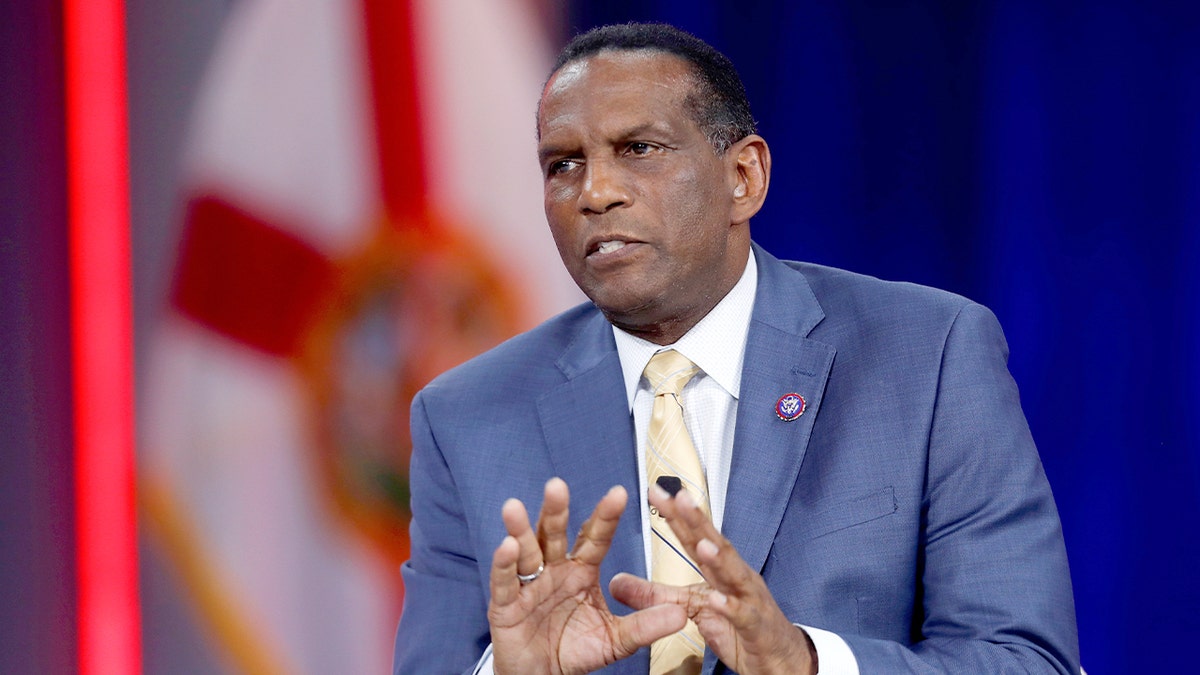 Burgess Owens participates in a conference panel discussion.