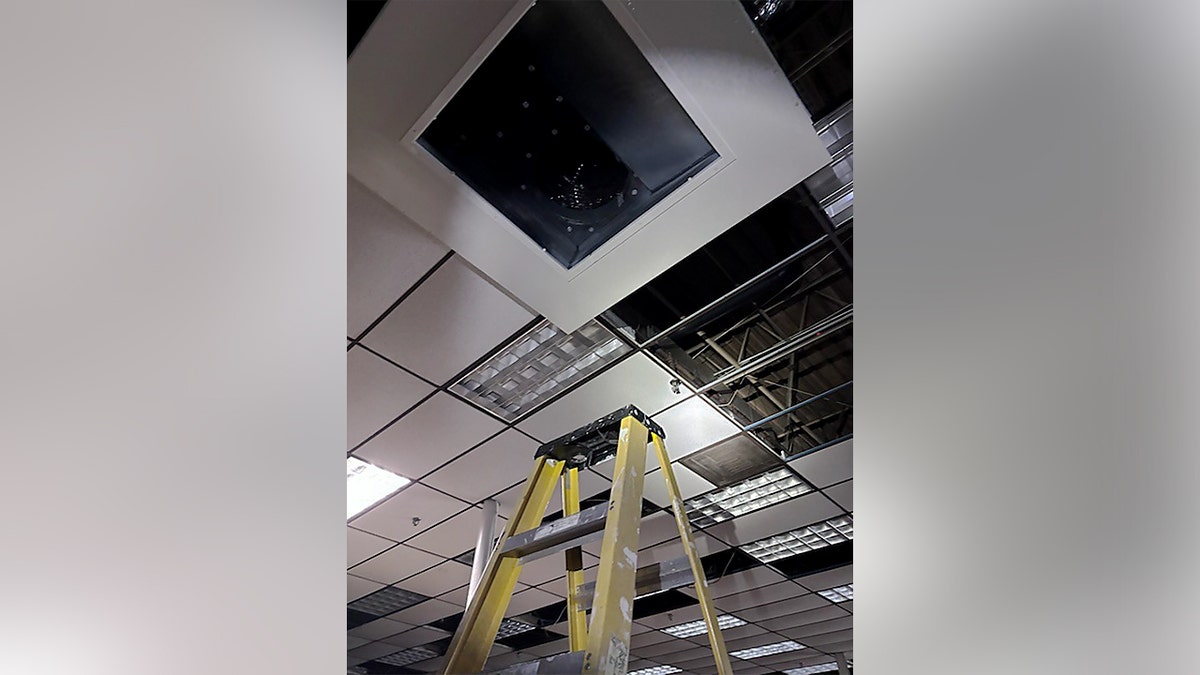 Yellow ladder under an air vent.