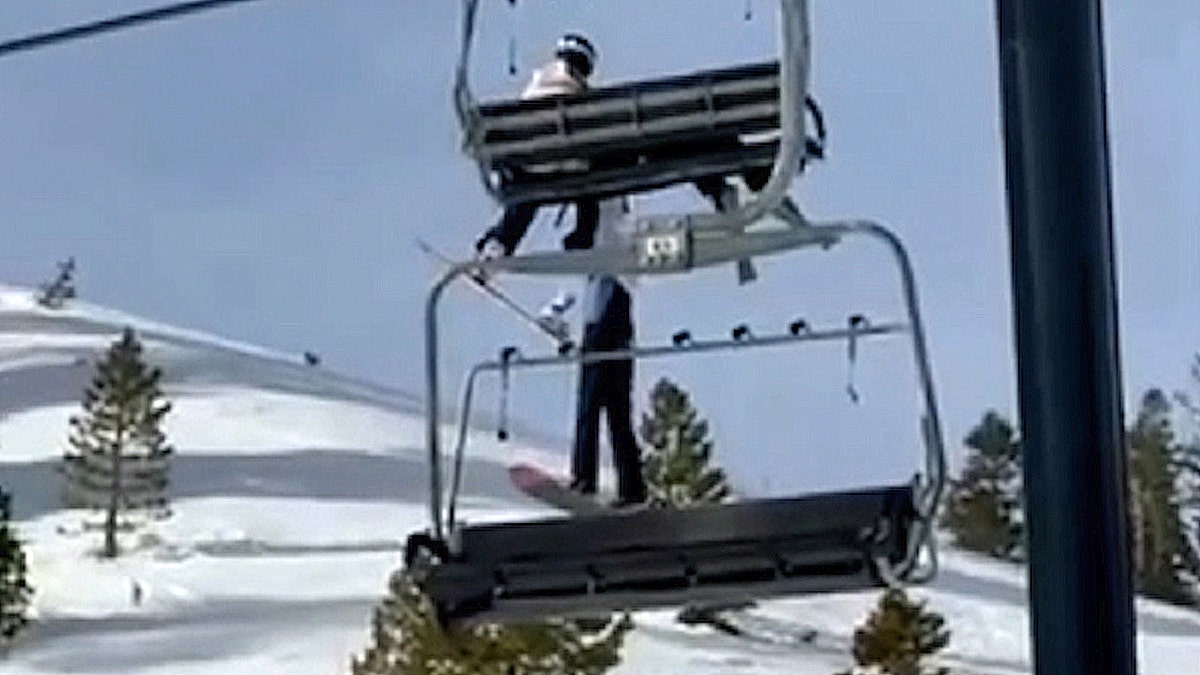 Una ragazza penzola dallo skilift sopra il pendio innevato di un resort in California