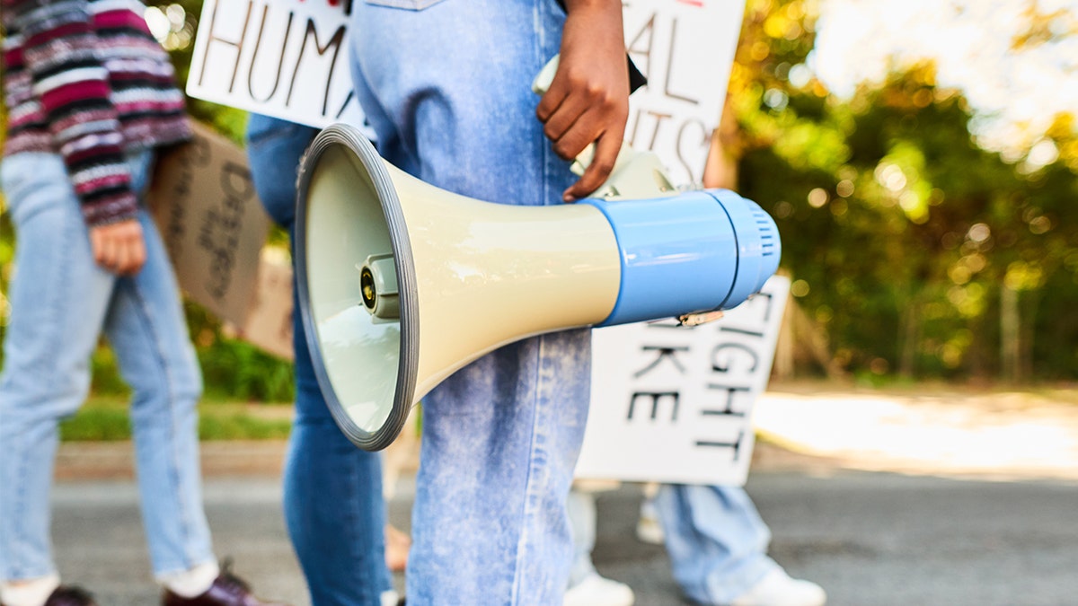 California school board member holding a megaphone during a protest