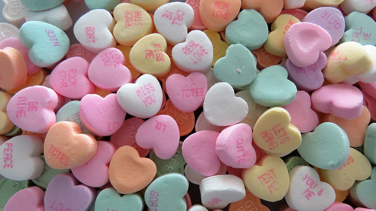 Pile of candy hearts with phrases like "kiss me," "real love," and "text me."